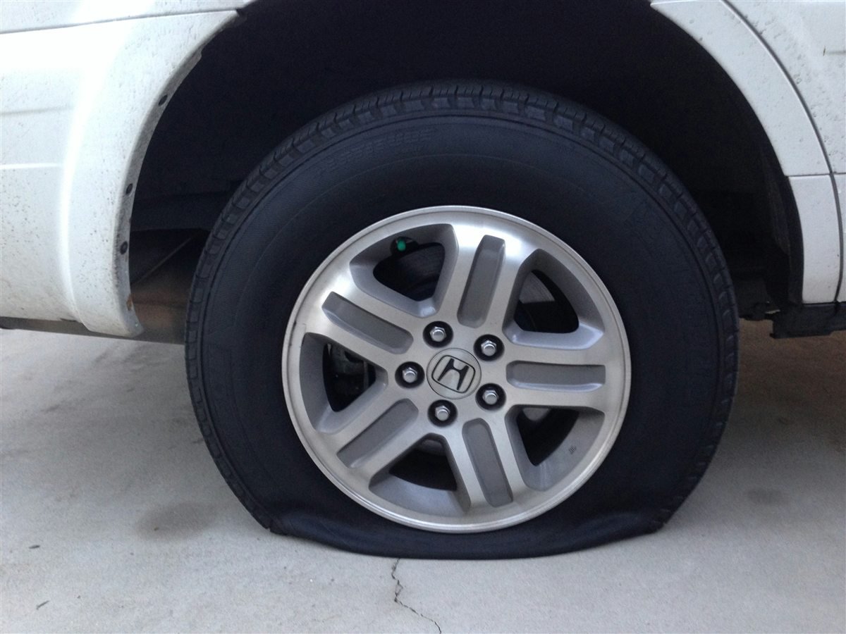 Flat tire on a white vehicle.